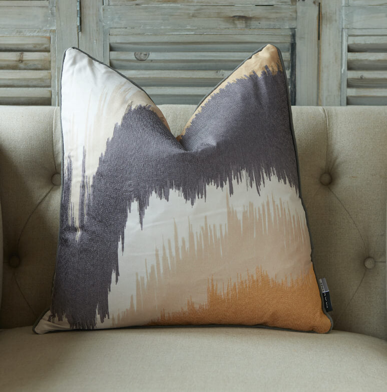 Abstract embroidered cushion in shades of grey, cream and mustard