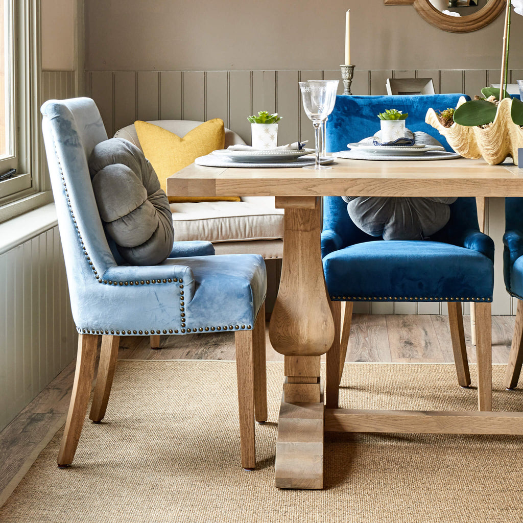Pale blue and royal blue velvet Hamilton dining chairs at one end of Belvedere weathered oak dining table